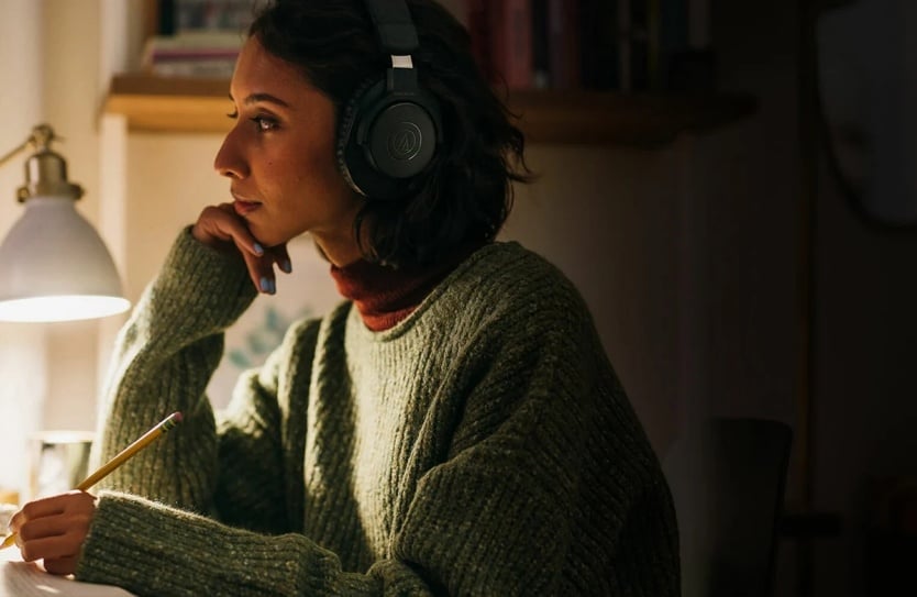 młoda kobieta siedzi w słuchawkach ATH-M20xBT