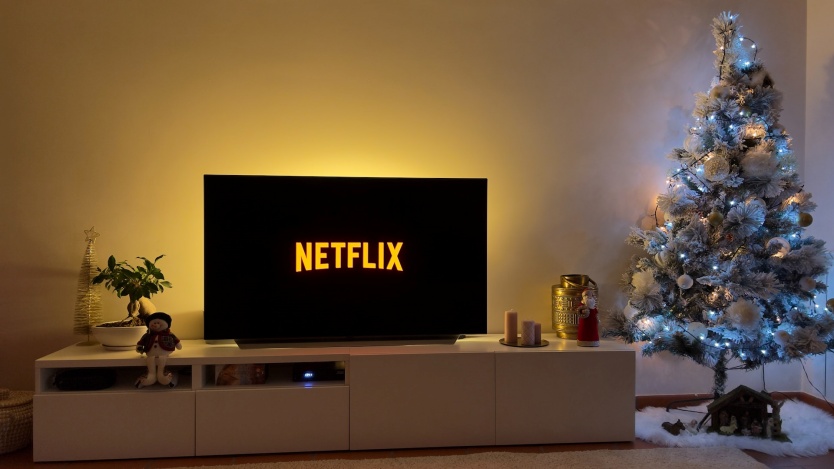 pomarańczowe logo netflix na ekranie, obok choinka