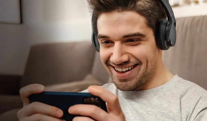 mężczyzna w słuchawkach audio-technica ATH-S220BT uśmiecha się do telefonu